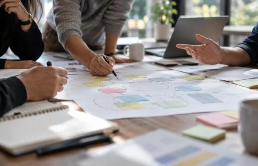 a meeting with paper set out across a table 