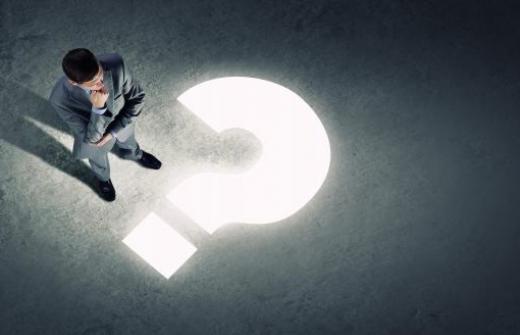 Man standing next to illuminated question mark