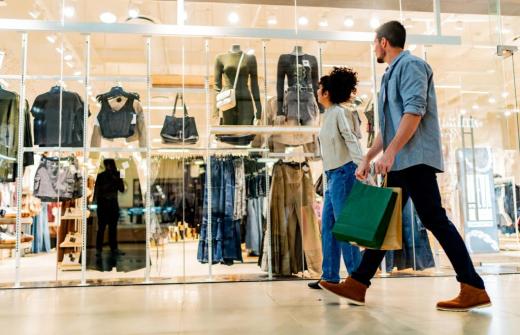 Two people walking past a shop front