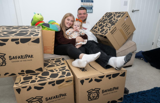 parents sitting on boxes holding a child