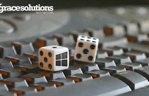 Two dice, each displaying 5 dots to make 10 in total. One of the die faces has the Microsoft windows logo. Both dices are sitting on a computer keyboard. v