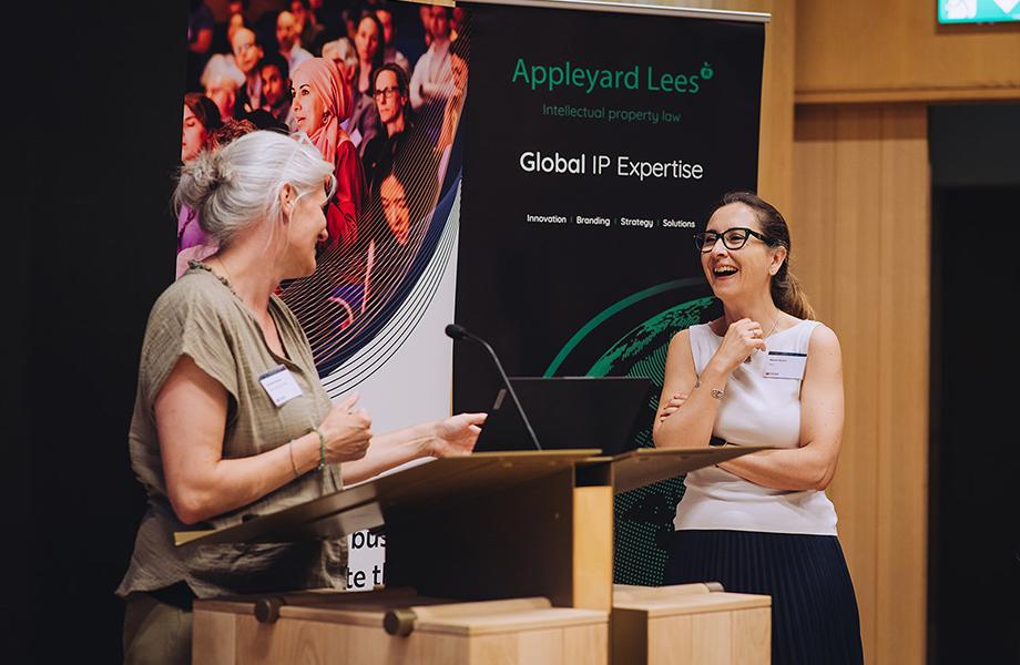 Two presenters at the 2025 Milner Pitch Day at a podium