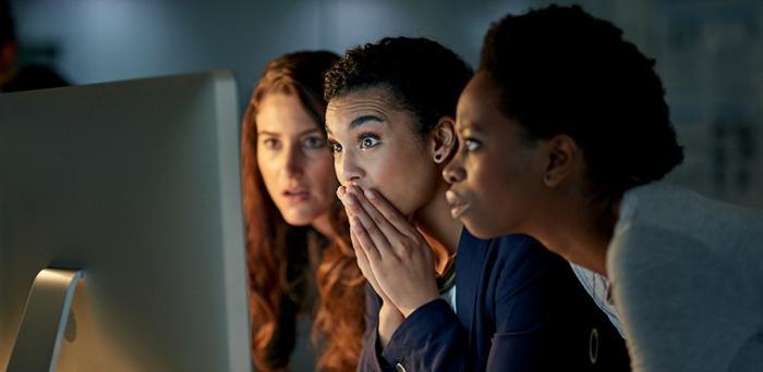 Three women looking in surprise at a computer screen