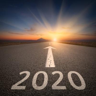 2020 in foreground, written on a road with an arrow, pointing to a sunset in the background
