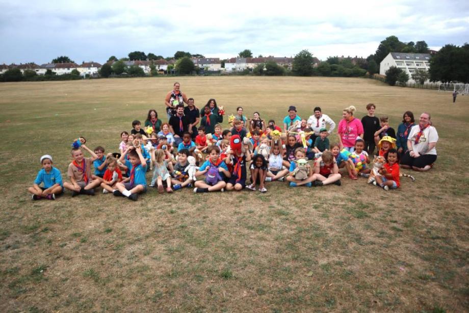 2nd Newmarket Scout Group sat together in a field looking at the camera