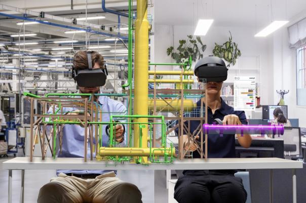 Two men wear augmented reality headsets and work with models _AVEVA Unified Supply Chain