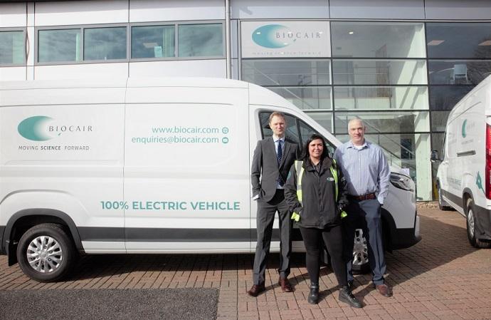 Biocair staff next to electric vehicle