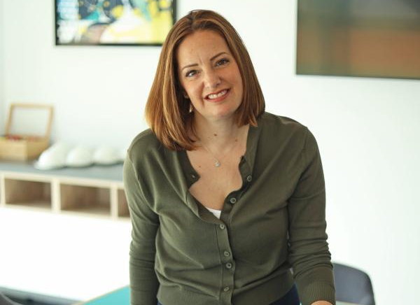 Claire Harris sat on the edge of the desk, looking at the camera