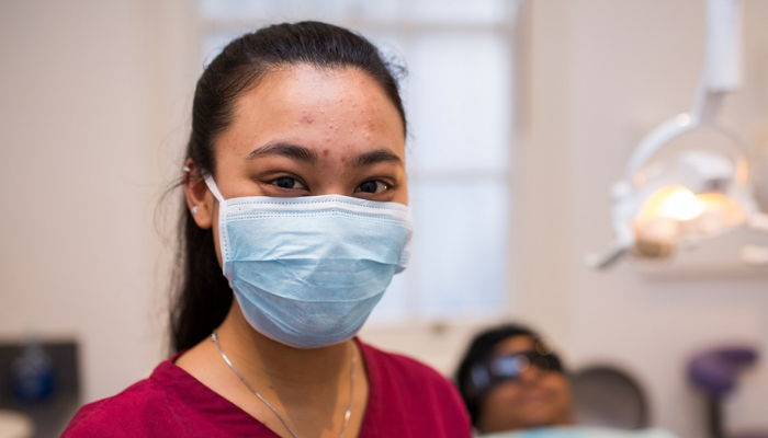 Dentist wearing mask with patient in background