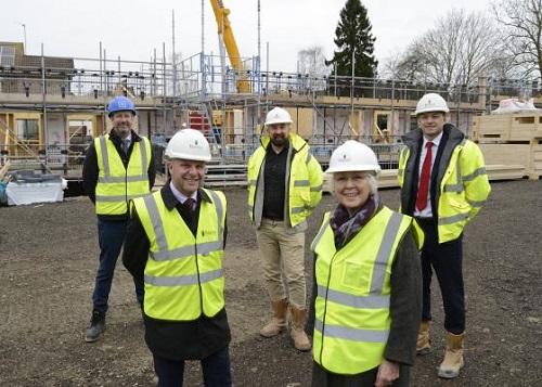 Marking a milestone at Dovehouse Court, left to right: Jamie Saunders, Director, Northmores; Mark Hart, Joint Managing Director, Barnes Construction; Ian Bramwell, Senior Associate, Mole Architects; Ann Bonnett, Chair Girton Town Charity; and Matthew Ramplin, Contracts Manager, Barnes Construction.