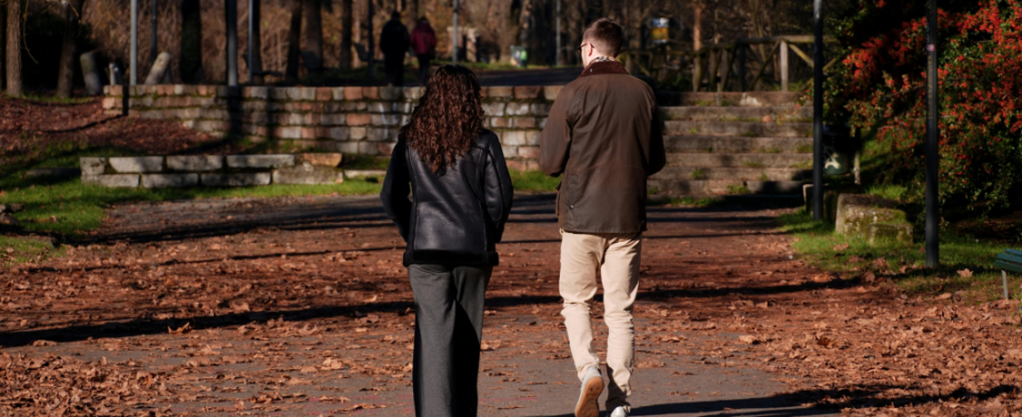 A man and a woman walking through a park