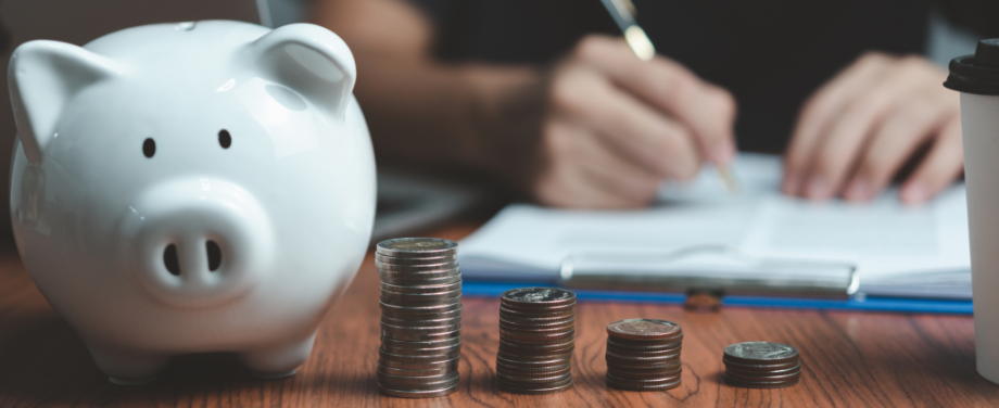 a white piggy bank with a row of coins stacked next to it