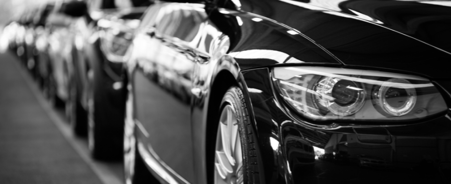 A BLACK AND WHITE PHOTO OF A ROW OF BLACK CARS