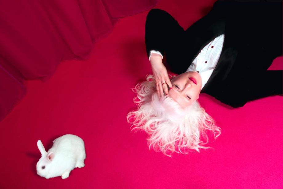 a lady on the floor with a white rabbit 