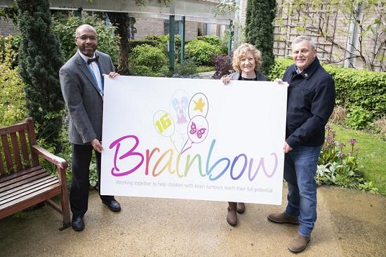 Clinical lead and paediatric oncologist, Dr Amos Burke, with Denise and Sean Tarrant, showing the new Brainbow logo.