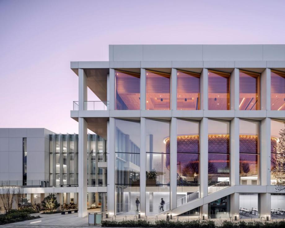 The white exterior of the Ray Dolby Centre with floor to ceiling windows over 3 floors. Now bookable for events via Meet Cambridge
