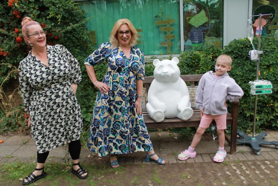 Pilgrim Pathways headteacher Nadine, with Sarah Bush, Head of Residential, at Cheffins, with the panda cub - and eight-year-old school pupil, Ava