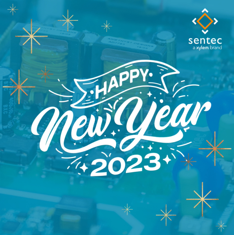 Message of "Happy New Year 2023" on a blue background with a printed circuit board pictured in the background. 