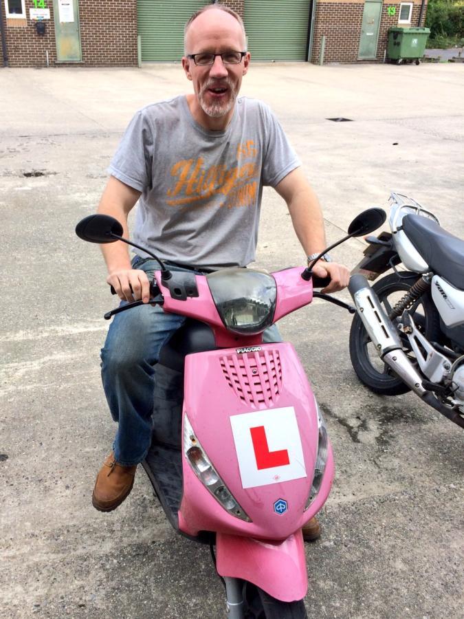 Simon on a very pink motor scooter