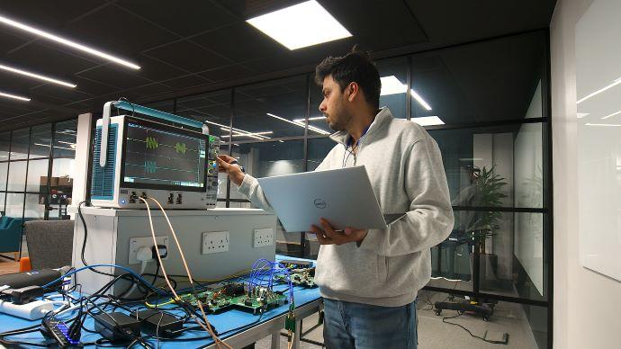 a man holding a computer working with hardware 