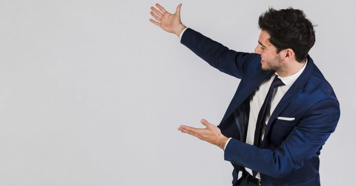 Man pointing at an empty white wall