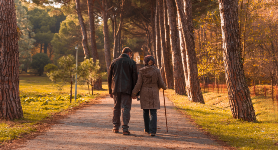an older couple taking a walk through the park