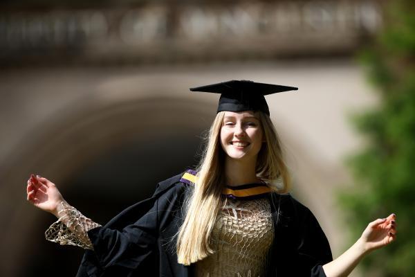 smiling girl graduate in gown and mortar board