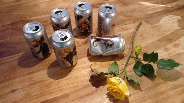 Empty BrewBoard cans and a yellow rose