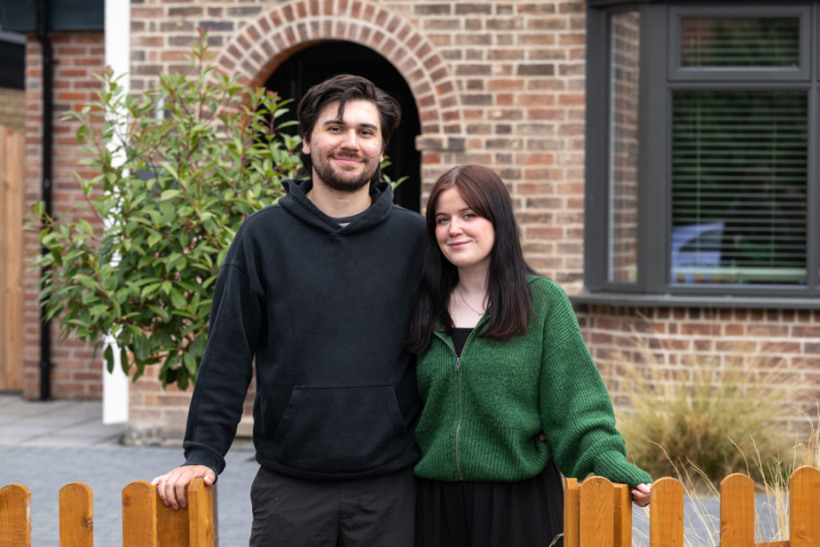 man and women standing in front of a house