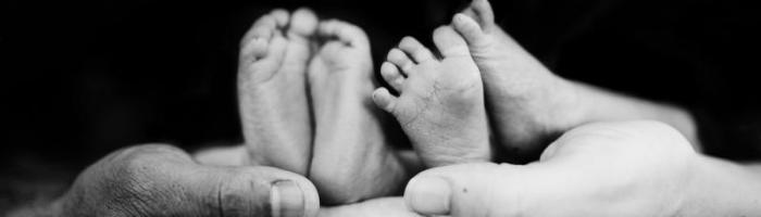 adlut hands holding baby's feet/ credit Michael Fallon, Unsplash.com