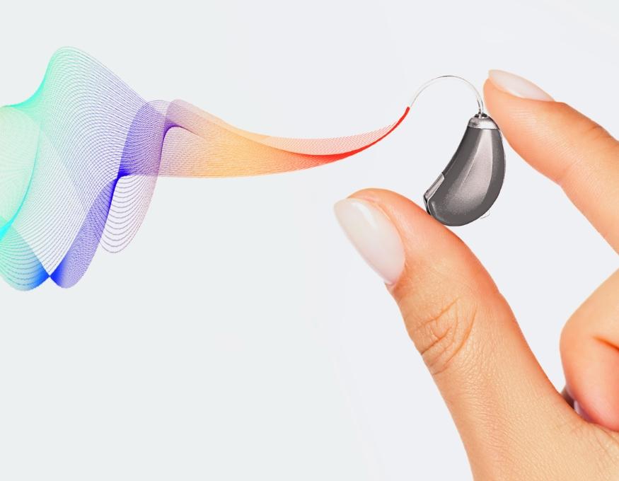 person holding small wearable hearing-aid