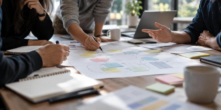 a meeting with paper set out across a table 