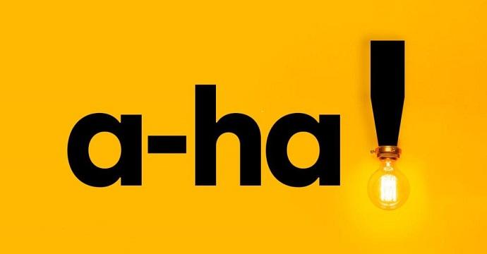 The word 'A-ha!' is spelled out with a lightbulb as the dot on the exclamation mark