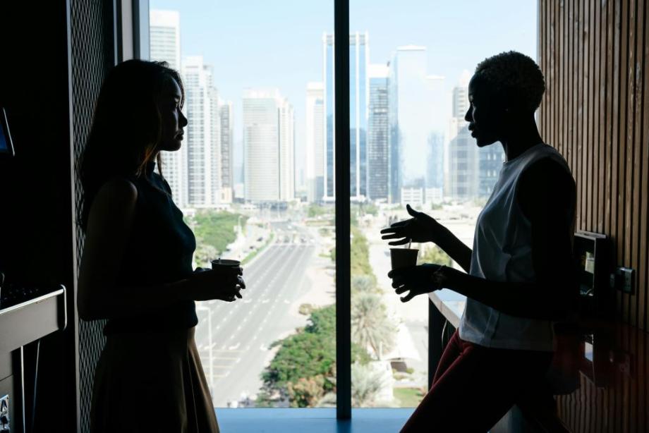 Two women standing in front of a high rise window