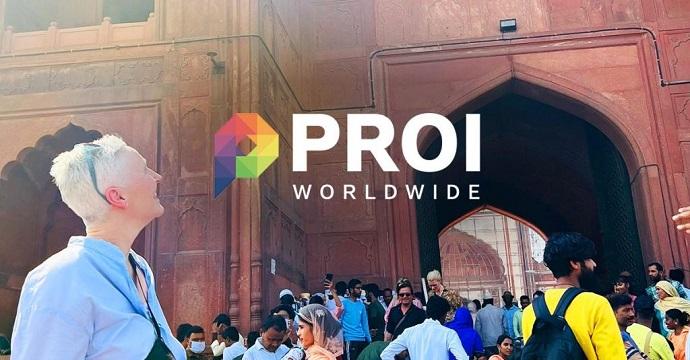 Sarah looking up to a building in India with the PROI logo overlaid on the image