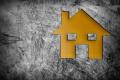 stylised graphic of a yellow house on a grey background