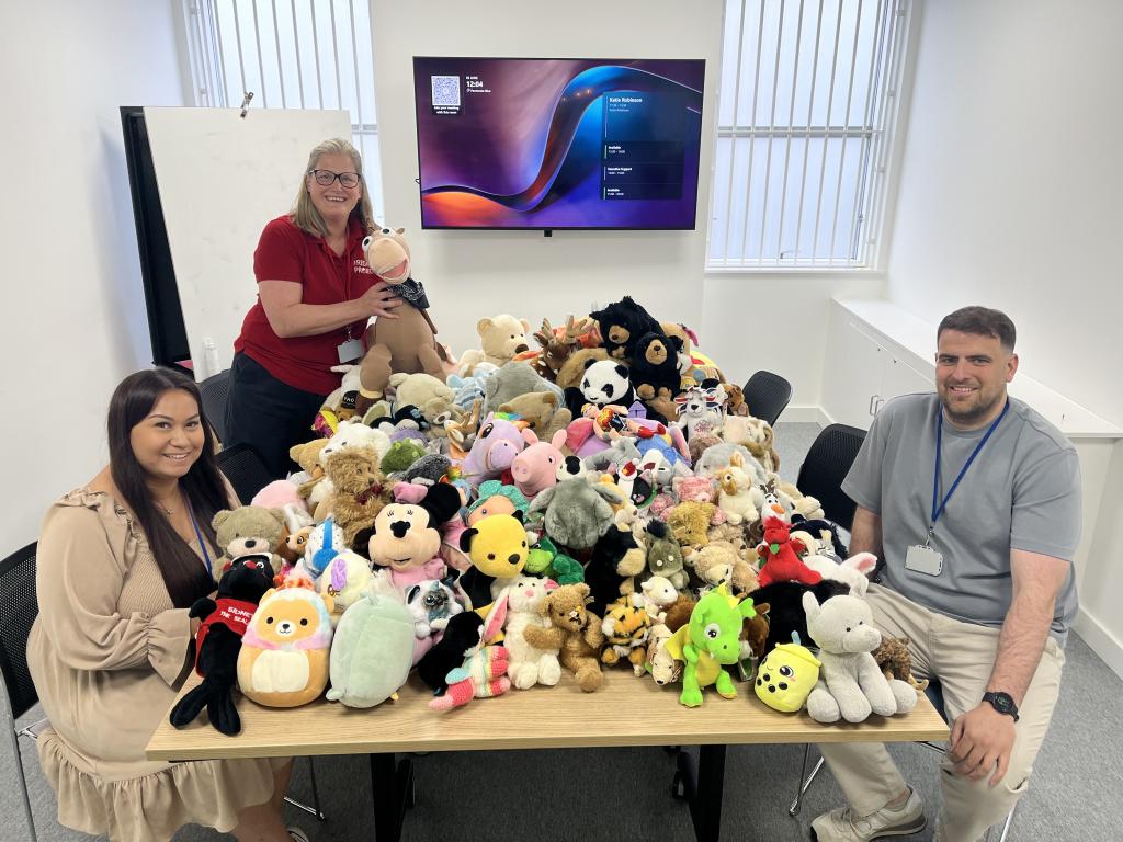 3 people and a table full of teddys