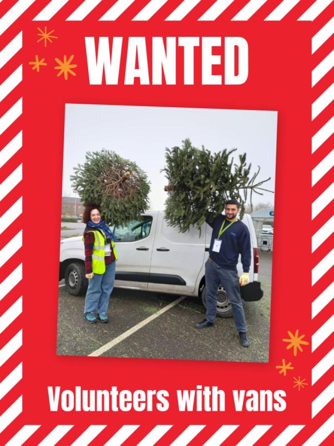 Photo of 2 volunteers loading Christmas trees into a van.