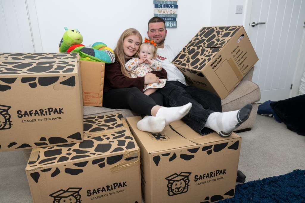 parents sitting on boxes holding a child