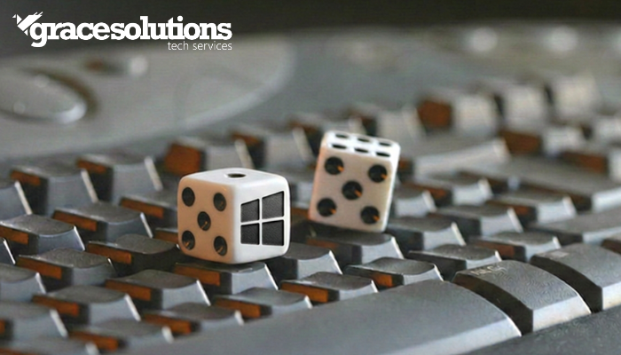 Two dice, each displaying 5 dots to make 10 in total. One of the die faces has the Microsoft windows logo. Both dices are sitting on a computer keyboard. v